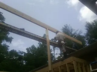 Carpenter setting a ridge beam over a new addition frame — Ice Dam Removal by Roofing Brothers in Ulster Park