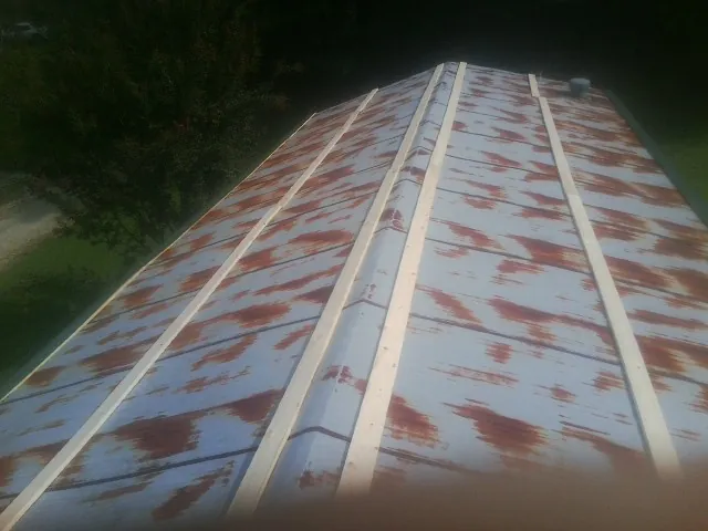 Rusted metal roof panels with new wood purlins before replacement — Storm Damage Roof Repair in Ulster Park by Roofing Brothers
