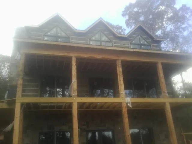 Dormers and porch framing on a large log home under construction — Roof Coating work by our crew in Ulster Park