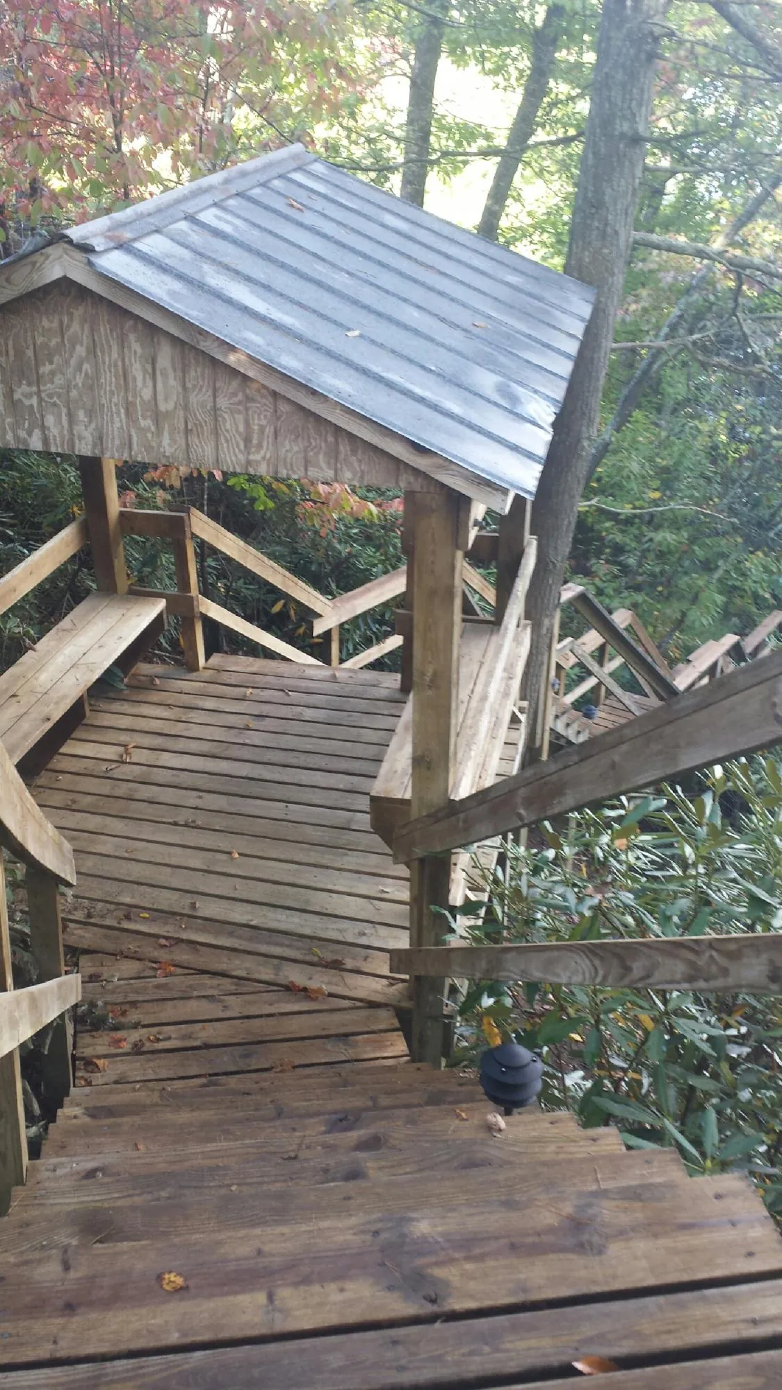 Metal roofed shelter over wooden steps on a wooded walkway — Skylight Repair & Installation work by our crew in Ulster Park