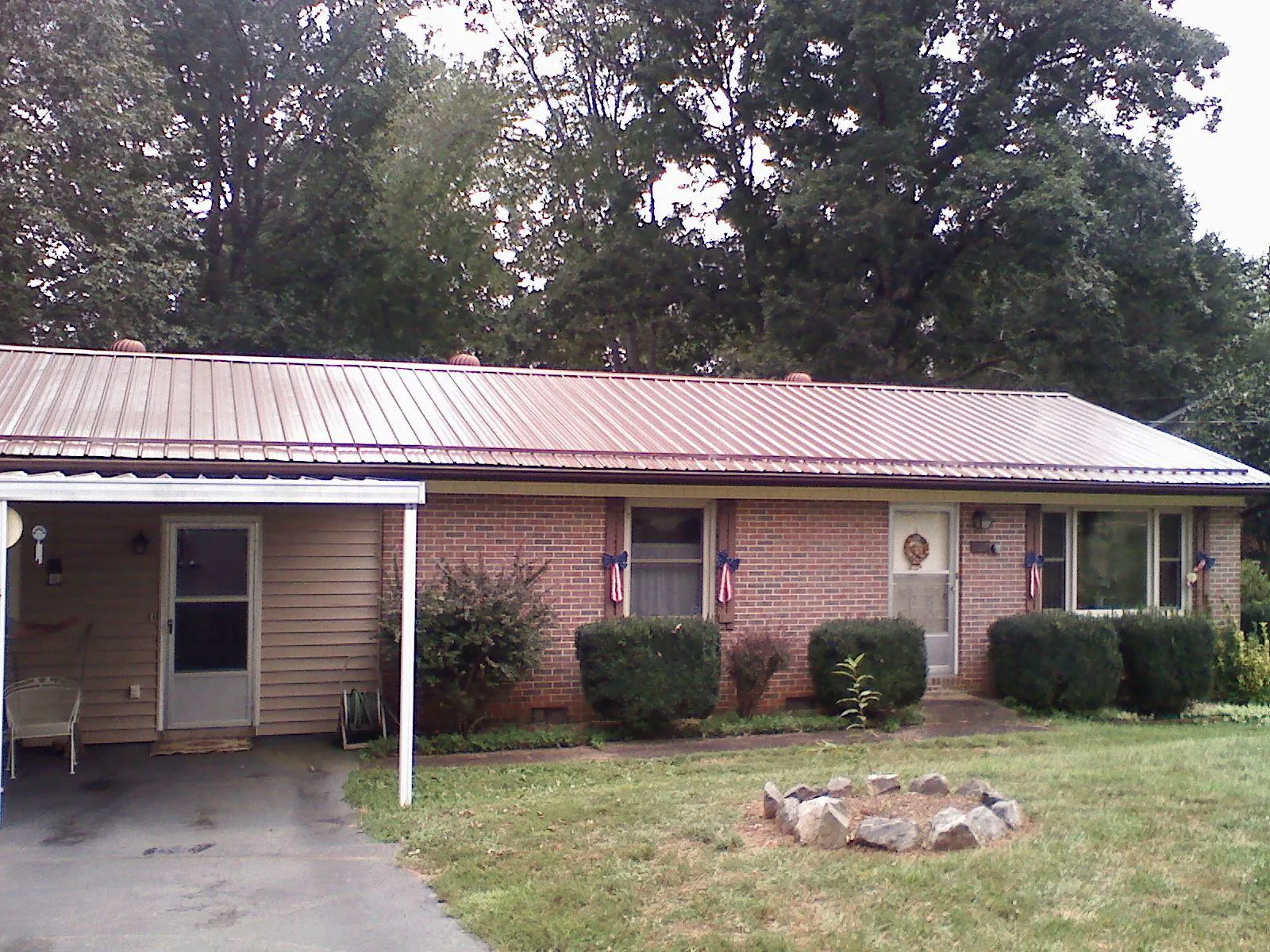 Bronze metal roof and carport on a brick ranch home — Roof Repair work by our crew in Ulster Park